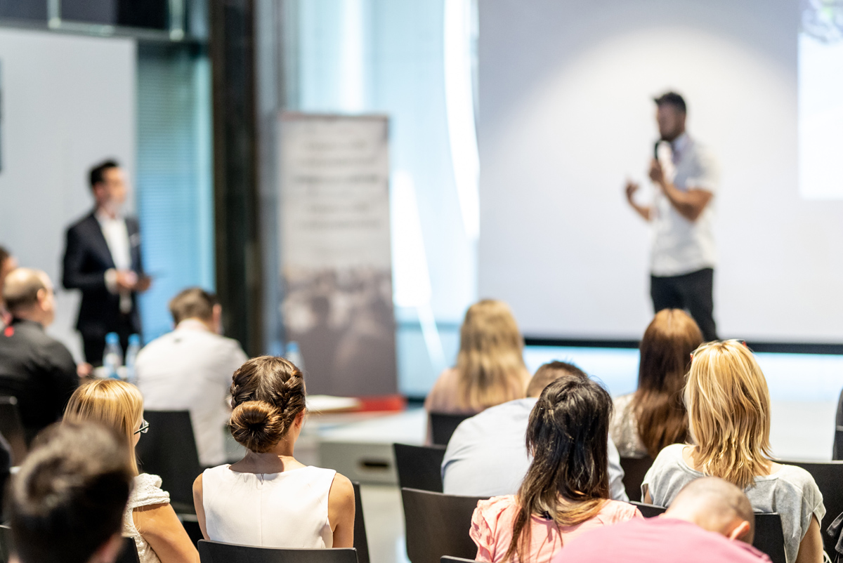 Person on stage speaking at ProductCON 2019. 